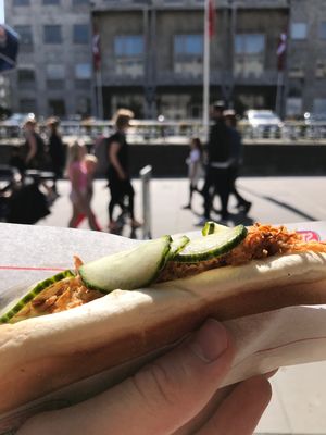 Aarhus Town Hall, 3 September 2017 Hand holding hotdog in front of Aarhus Town
                                                                                                                                     Hall